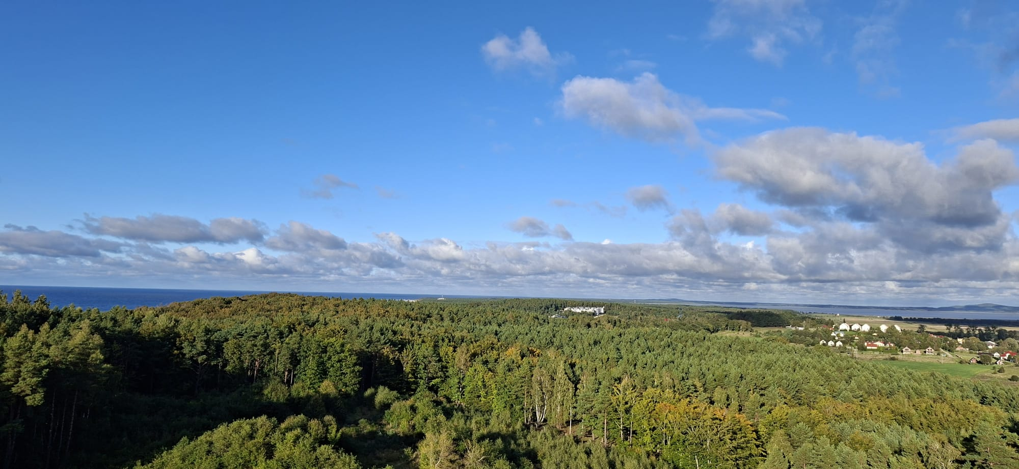 Panorama z góry: Morze Bałtyckie po lewej, las pośrodku i jezioro Gardno po prawej